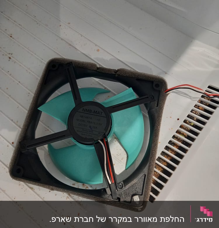 מאוורר פלסטיק עם להבים ירוקים וחוטים חשמליים